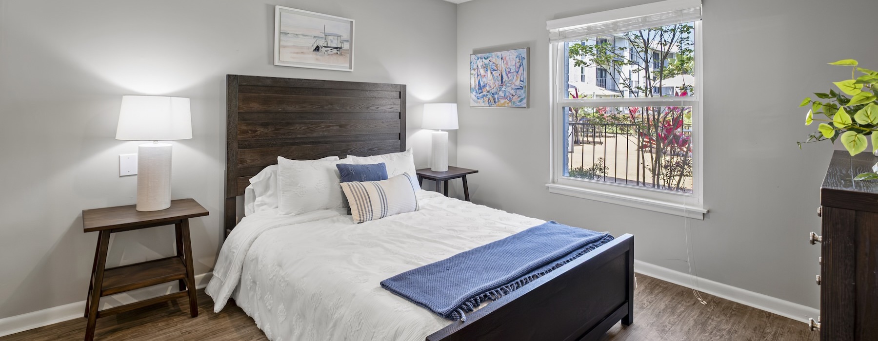 bedroom with bed wall art and large window